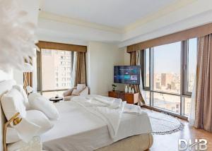 a bedroom with a white bed and a large window at The St Regis Luxury in Cairo