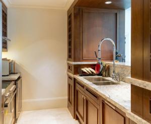 a kitchen with wooden cabinets and a sink at The St Regis Luxury in Cairo +14 photos