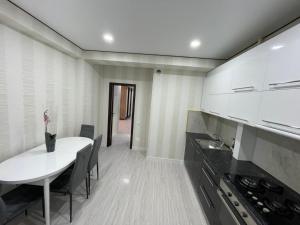 a kitchen with a white table and a dining room at Apartament in Chişinău