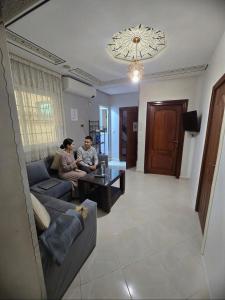 a man and woman sitting on a couch in a living room at Hostel Dar Khelifa in Tétouan