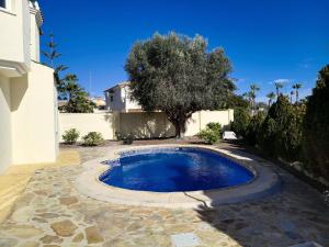 a swimming pool in a yard with a tree at Villa Elegante, with a private pool in Murcia