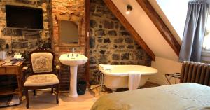 a bathroom with a sink and a tub in a room at Manoir Sur le Cap in Quebec City +58 photos