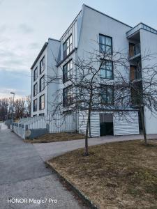ein weißes Gebäude mit einem Baum davor in der Unterkunft Tellus Apartment in Lund