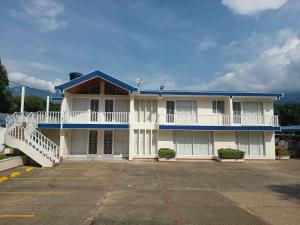 a large white building with a blue roof at Hotel Cabaleón in Tena