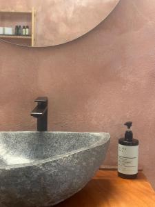 a bathroom sink with a bottle of soap next to it at Leti Hydra in Hydra +8 photos