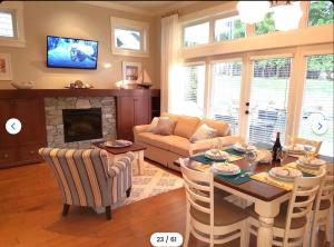 a living room with a table and a fireplace at Qualicum Landing Coastal Cottage in Qualicum Beach