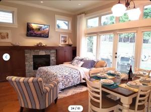 a bedroom with a bed and a table and a fireplace at Qualicum Landing Coastal Cottage in Qualicum Beach