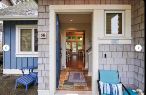 a front door of a house with two blue chairs at Qualicum Landing Coastal Cottage in Qualicum Beach