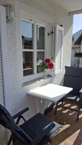 a white table and chairs on a balcony with a window at Stadthaus Sonneneck in Bad Tölz