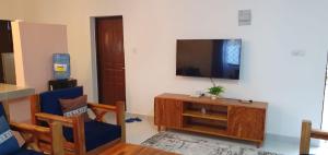 a living room with a flat screen tv on a wall at TajiS Diani Chic 1 BR with swimming pool in Diani Beach +1 photo