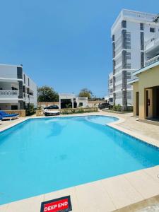 a large blue swimming pool in a building at TajiS Diani Chic 1 BR with swimming pool in Diani Beach