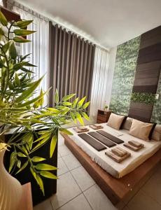 a living room with a bed and a large plant at Copacabana, Design Elegante A 100m Do Mar in Rio de Janeiro