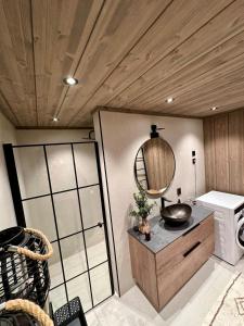 a bathroom with a sink and a mirror on a counter at Cabin with sea view in Moen