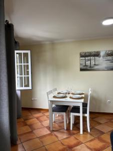 a dining room with a white table and chairs at Machico Village Apartment - Private terrace & car park in Machico +24 photos