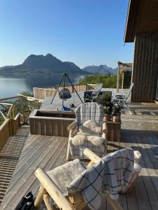 a deck with two chairs and a view of the water at Cabin with sea view in Moen