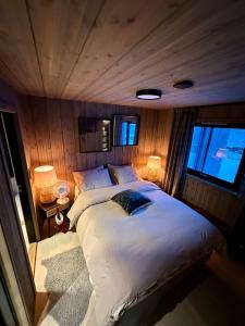 a bedroom with a large bed in a boat at Cabin with sea view in Moen