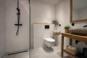 a bathroom with a shower and a toilet and a sink at Hotel de Koningsherberg in Anloo