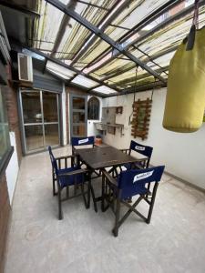 a dining room with a table and blue chairs at Peatonal Santafesina in Santa Fe
