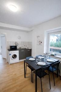 a dining room with a table and chairs and a kitchen at Die ANS Group Cozy Apps in Detmold