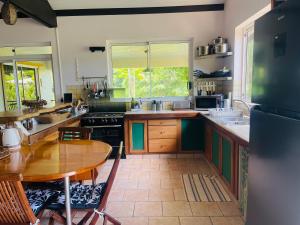a large kitchen with a wooden table and a table and a tableablish at Villa BOUDDHA- Raiatea in Uturoa