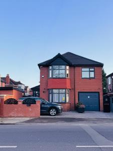 a red brick house with a car parked in front of it at United Home B&B in Manchester