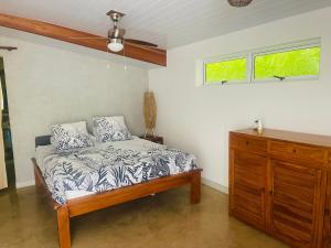 a bedroom with a bed and a wooden dresser at Villa BOUDDHA- Raiatea in Uturoa