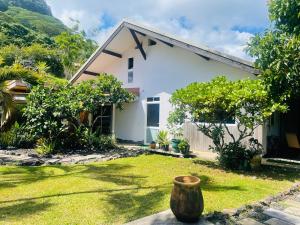 a small white house with a yard with a yard at Villa BOUDDHA- Raiatea in Uturoa