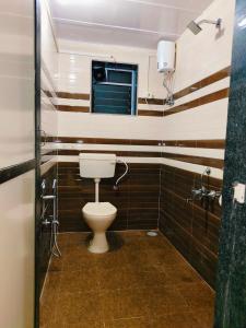 a bathroom with a toilet and a window at Varsha farm house in Guhagar +23 photos