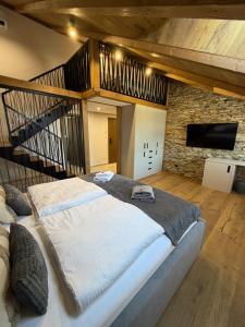 a bedroom with a large bed and a staircase at Vila Vento in Veľký Slavkov