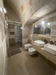 a bathroom with two sinks and a shower and two toilets at Barbacana Monopoli in Monopoli