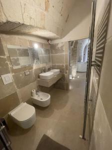 a bathroom with two sinks and a toilet and a shower at Barbacana Monopoli in Monopoli