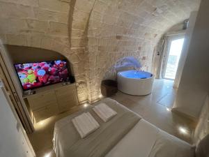 a room with a bed and a tv and a tub at Barbacana Monopoli in Monopoli +74 photos
