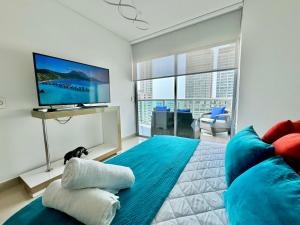 a bedroom with a blue bed with a flat screen tv at Apartamento Special For You in Cartagena de Indias