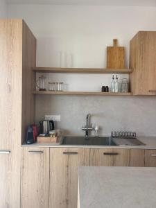 a kitchen with wooden cabinets and a sink at Terra Rossa Residences in Paralimni
