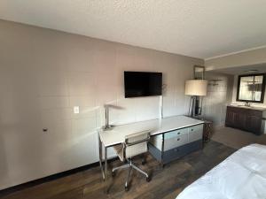 a bedroom with a desk and a tv on a wall at Deluxe Inn in Mauldin