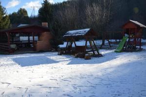a playground in the snow with a slide at Pensiunea Bucurie in Căpăţîneni-Ungureni