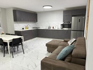 a living room with a couch and a table and a kitchen at Beit Shemesh gimmel apartment in Beit Shemesh