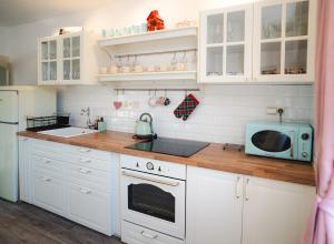 a kitchen with white cabinets and a microwave at CHalupa Relax in Dolní Lomná
