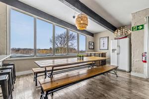 a dining room with a table and some windows at Mountain View-Backyard-Air-Conditioning-BBQ-15mins walk Blue Mountain Village in Blue Mountains