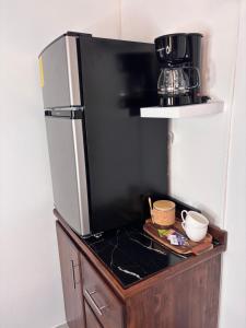 a kitchen with a refrigerator and a coffee maker on a counter at Orquídea de la Paz in Coco