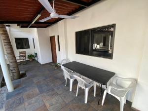 a dining room with a black table and white chairs at Costa Ayala - Suites & Bungalows in Los Ayala