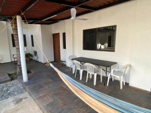 a hammock around a table and chairs on a patio at Costa Ayala - Suites & Bungalows in Los Ayala
