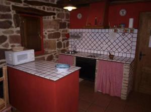 a kitchen with a counter with a microwave and a stove at CASA RURAL MATÉ in Susilla +9 photos