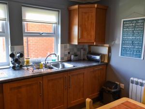 a kitchen with wooden cabinets and a sink and a window at Brada View in Bamburgh