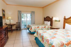 a hotel room with two beds and a television at Telamar Resort in Tela