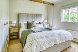 a bedroom with a large bed with towels on it at Gleanings Cottage in Bredon