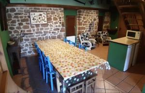 a table and chairs in a kitchen with a stone wall at CASA RURAL MATÉ in Susilla
