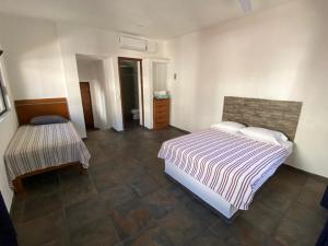 a bedroom with a bed and a table in it at Costa Ayala - Suites & Bungalows in Los Ayala +51 photos