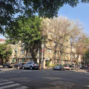 a street with cars parked on the side of the road at Hotel polly in Mexico City
