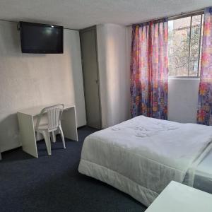 a hotel room with a bed and a desk and a television at Hotel polly in Mexico City +10 photos